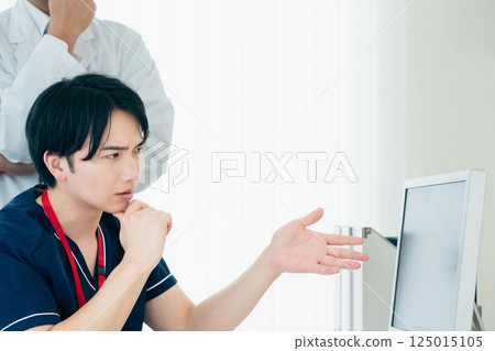 Male doctors looking at data and discussing Male doctors looking at data and discussing 125015105