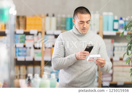 Man scans code on package of paracetamol pills to check expiration date 125015936