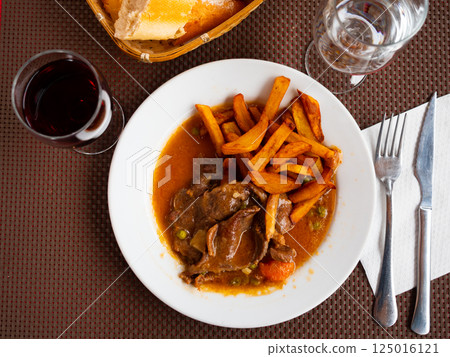 Stewed beef in sauce served with potatoes on platter Stewed beef in sauce served with potatoes on platter 125016121