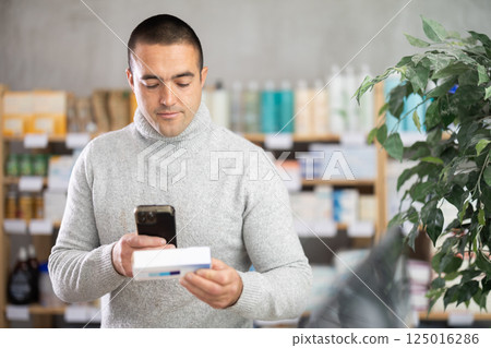 Man scans code on package of pills to check expiration date Man scans code on package of pills to check expiration date 125016286