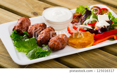 Minced meat kebapcheta served with salad of greens and brynza Minced meat kebapcheta served with salad of greens and brynza 125016317