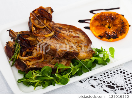 Grilled pork meat with fried orange and corn salad 125016350