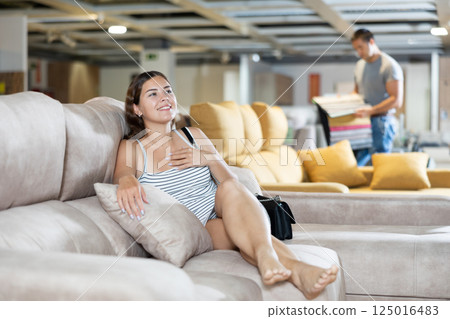 Female customer choosing comfortable lounge furniture in store Female customer choosing comfortable lounge furniture in store 125016483
