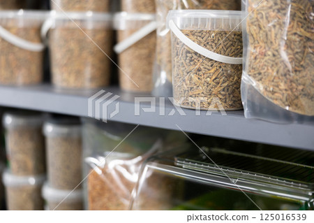 Pet shop display shelf with packages of pellets for feeding turtles Pet shop display shelf with packages of pellets for feeding turtles 125016539