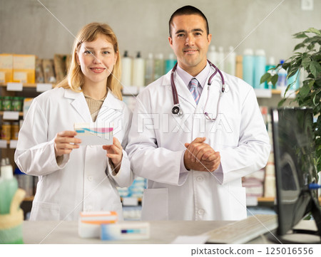 Two pharmacists invite customers to the pharmacy 125016556