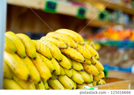 Bunches of yellow bananas on the stand in open-air fruit and vegetable market 125016666