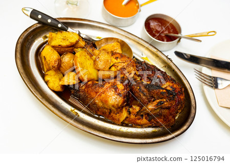 Roasted chicken with potatoes and two sauces Roasted chicken with potatoes and two sauces 125016794