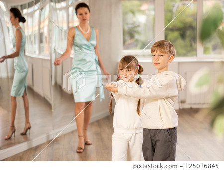 Boy and girl in sport wear train to dance contemporary vigorous rumba during classes. 125016845