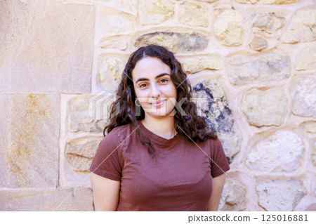 European girl smiling in front of bricks 125016881