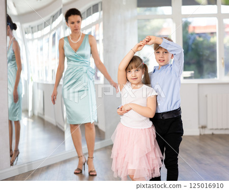 Boy and girl in pair train to dance contemporary vigorous waltz during classes. Boy and girl in pair train to dance contemporary vigorous waltz during classes. 125016910