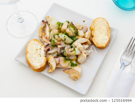 Grilled calamari and two pieces of bread served in a plate 125016994