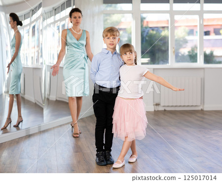 Boy and girl in pair train to dance contemporary vigorous hustle during classes. 125017014