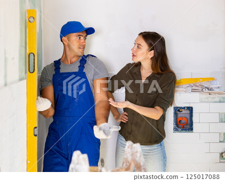 Woman dissatisfied with work done by the builder to renovate bathroom Woman dissatisfied with work done by the builder to renovate bathroom 125017088
