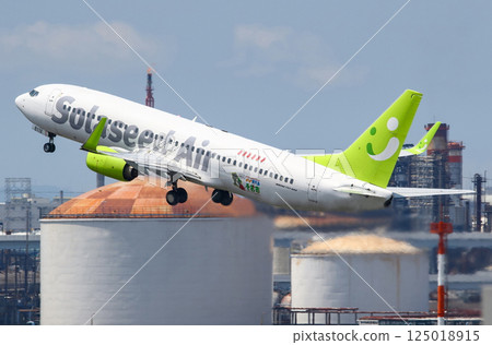 Solaseed Air B737-800 taking off against the background of Haneda factory 125018915