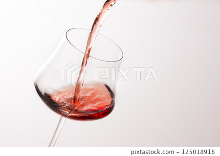 Pour the red wine into the glass 125018918