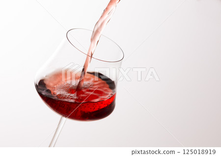 Pour the red wine into the glass 125018919