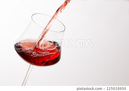 Pour the red wine into the glass Pour the red wine into the glass 125018930