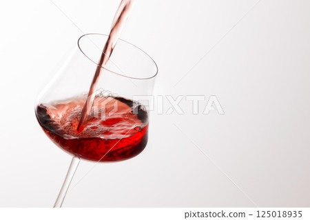 Pour the red wine into the glass 125018935