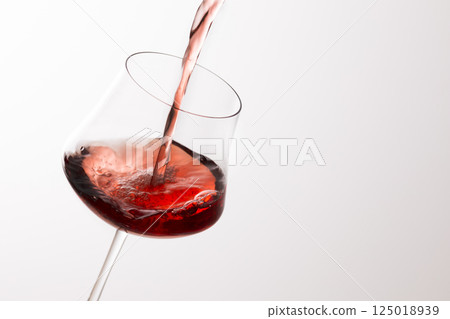 Pour the red wine into the glass Pour the red wine into the glass 125018939