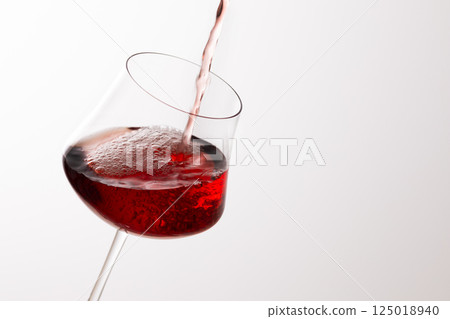 Pour the red wine into the glass 125018940