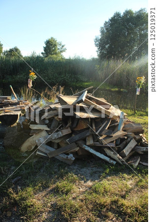 A pile of firewood lies in bulk, piled up to light a fire, a fire of flame. Campfire on the street A pile of firewood lies in bulk, piled up to light a fire, a fire of flame. Campfire on the street 125019371