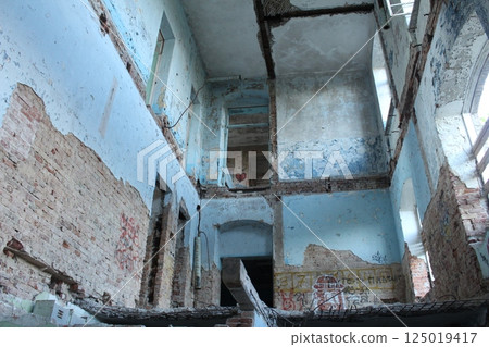 A destroyed house inside without ceilings and stairs. Vandalism, war, devastation A destroyed house inside without ceilings and stairs. Vandalism, war, devastation 125019417