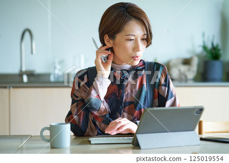 Woman working in the living room 125019554