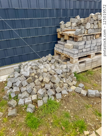 Cobblestones stacked on pallets for paving work at outdoor construction site. High quality photo 125019572