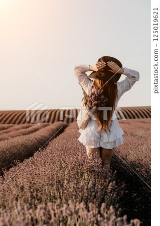 Woman in a White Dress and Hat in a Lavender Field 125019621