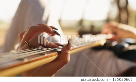 Girl Plays Bass Musical Instrument Lying On Table In Mountains 125020605