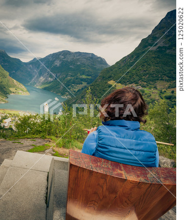 Tourist enjoying Geirangerfjord from viewing point Tourist enjoying Geirangerfjord from viewing point 125020622