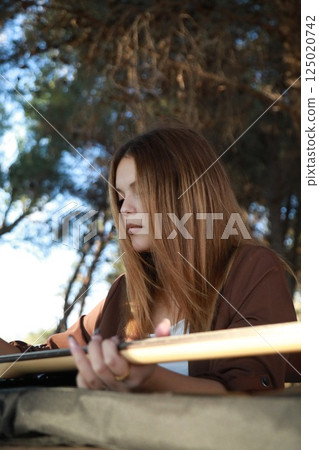 Girl Plays Bass Musical Instrument Sitting In Table In The Mountain Forest Girl Plays Bass Musical Instrument Sitting In Table In The Mountain Forest 125020742