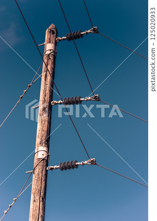 Power line voltage tower against blue sky 125020933