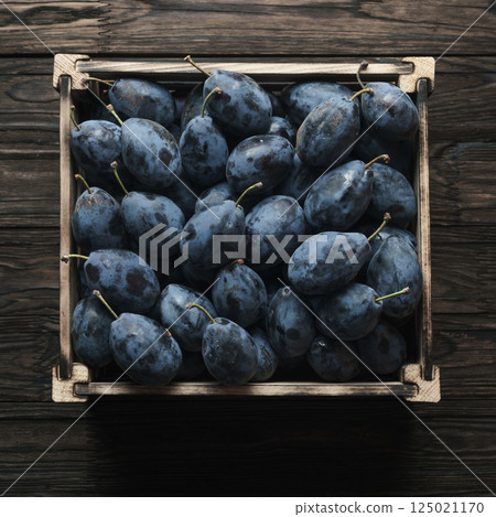Fresh plums in wooden box 125021170