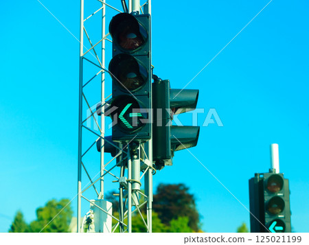 Green traffic lights against blue sky background 125021199