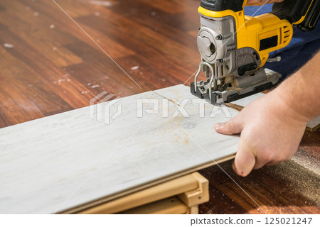 Person cutting floor panels 125021247