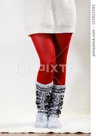 Woman legs wearing woolen socks and red tights 125021583