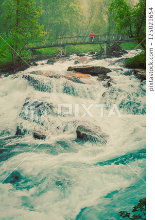Tourist on river bridge, Norway 125021654