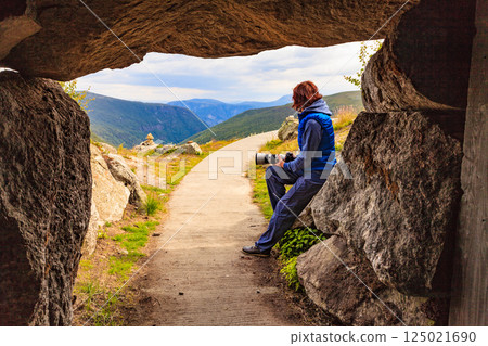 Tourist on Vedahaugane cave entrance, Norway Tourist on Vedahaugane cave entrance, Norway 125021690