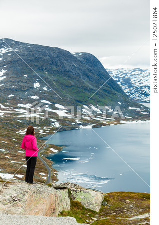 Tourist woman standing by Djupvatnet lake, Norway 125021864