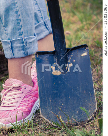 Woman digging hole in garden 125022069