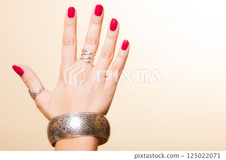 Female hand with manicure and armlet 125022071