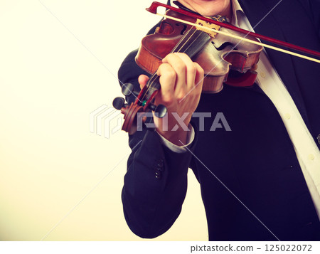 Man man dressed elegantly playing violin 125022072