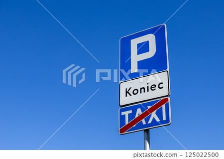 End of taxi parking zone traffic sign with blue background and clear lettering on bright sunny day under blue sky 125022500