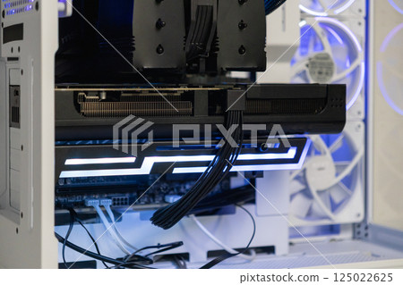 High-end graphics card installed in gaming PC with illuminated support bracket for secure mounting and cable management in modern case 125022625