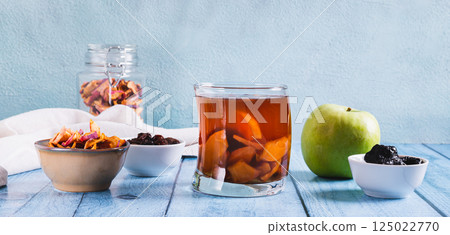 Traditional drink made from prunes, raisins and apples uzvar in a glass on the table web banner Traditional drink made from prunes, raisins and apples uzvar in a glass on the table web banner 125022770
