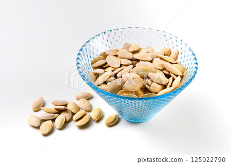 Many pumpkin seeds in glassware with on white background Many pumpkin seeds in glassware with on white background 125022790