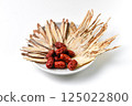 Various Chinese medicinal herbs gathered on a white ceramic plate 125022800