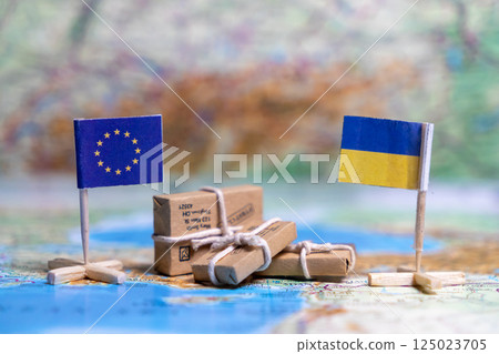 Flag of the European Union and Ukraine on the world map next to delivered parcels. Economy, aid, trade 125023705