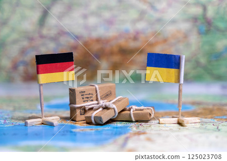 Flag of Germany and Ukraine on the world map next to delivered parcels. Economy, aid, trade 125023708